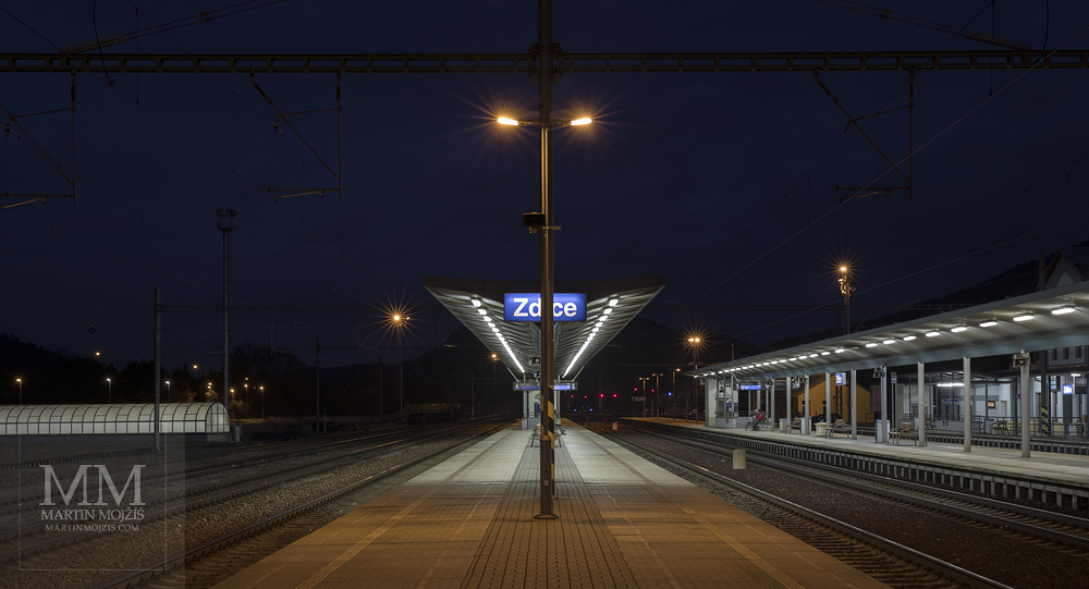 Železniční nádraží v noci. Fotografie zhotovená objektivem Canon RF 28 – 70 mm 1 : 2 L USM.